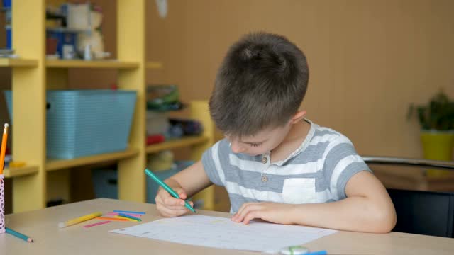 一个学龄男孩在家做家庭作业。在学校培训视频素材