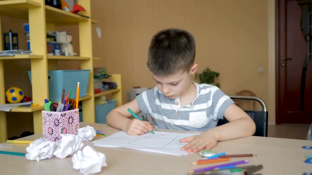 一个学龄男孩在家做家庭作业。在学校培训视频素材