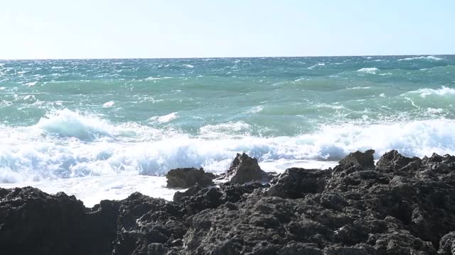 在普利亚，意大利海岸的黑色岩石的海浪冲击全景视频素材