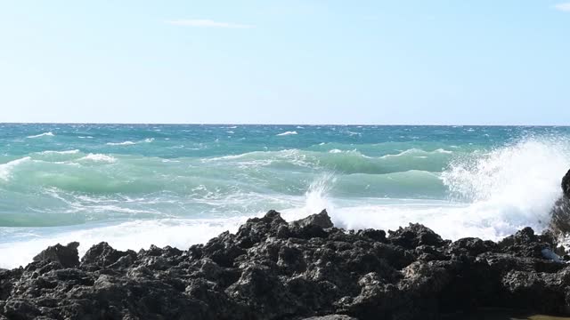 在普利亚，意大利海岸的黑色岩石的海浪冲击全景视频素材