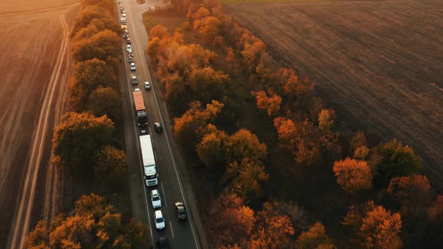 傍晚乡村公路上的汽车朝交通堵塞方向行驶的汽车鸟瞰图。视频素材