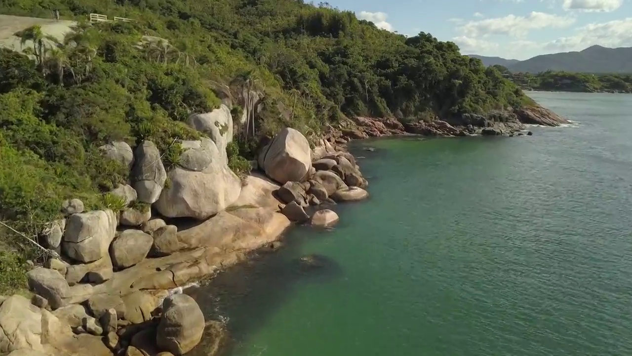 空中Pan沿着光滑的岩石海岸绿色-蓝色水域自然池Barra Da Lagoa Florianopolis巴西(无人机- 4K)视频下载