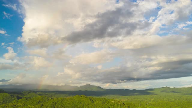 Hyper lapse 4K Amazing Rainbow after the rain over the forest。云时间流逝。山景，彩虹在山和戏剧性的云。视频素材