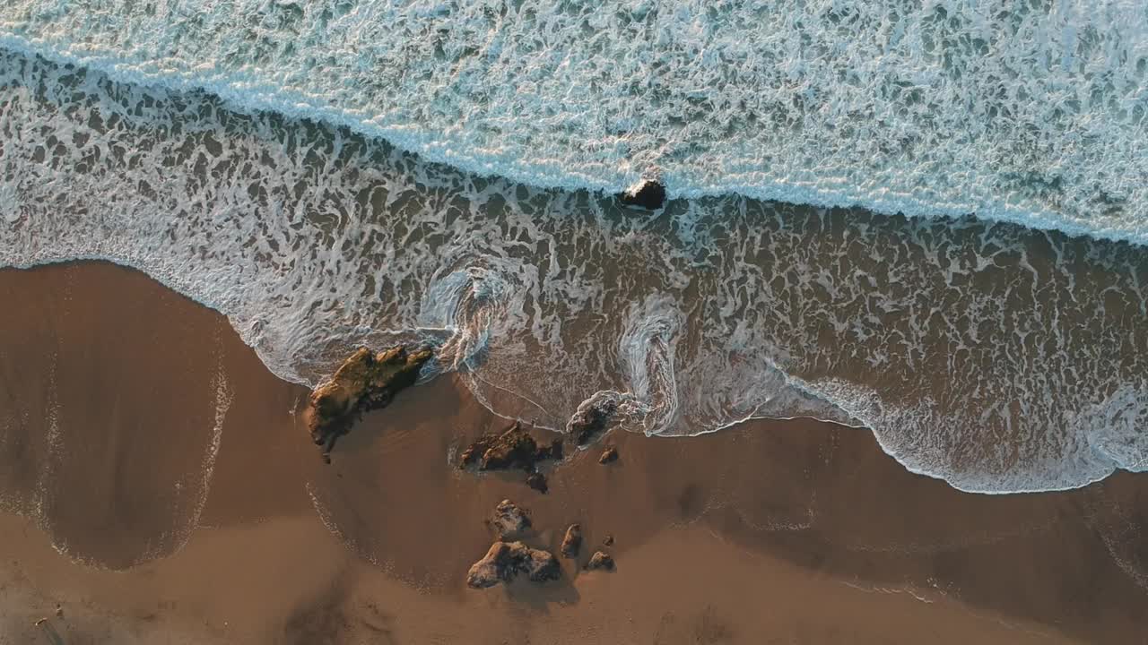 鸟瞰图海浪打破白色沙滩。海浪上美丽的海滩鸟瞰无人机视频素材