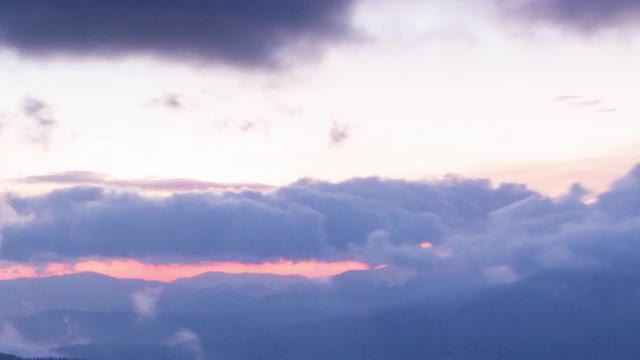 浪漫的五颜六色的日出在山上。太阳升起，蓝色和橙色的云在天空中流动。雄伟的奇妙景观。慢镜头以4K镜头为间隔。视频素材