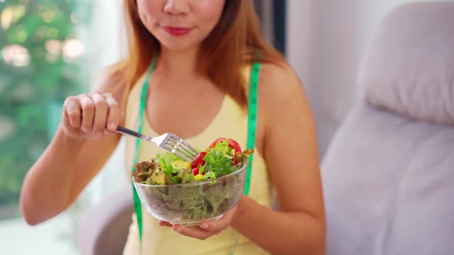 年轻女性在家吃自制的健康沙拉，健康的饮食方式和饮食理念视频素材