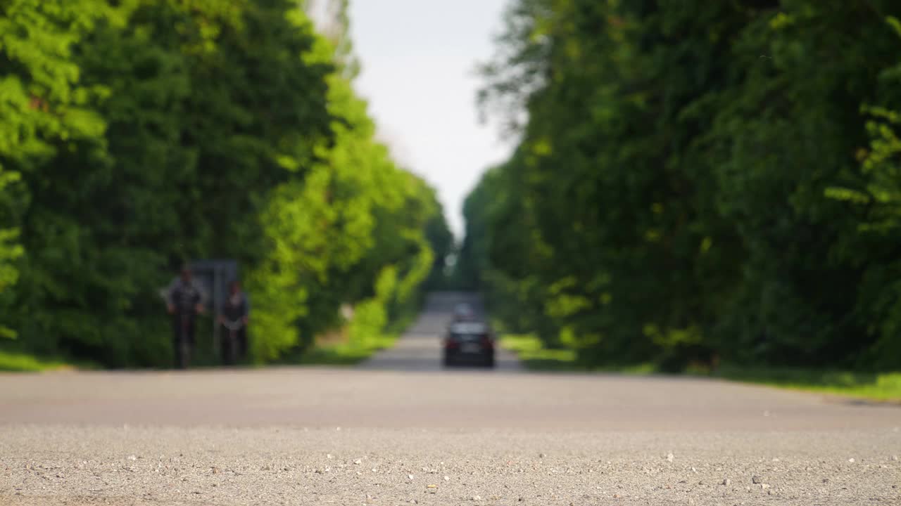 汽车行驶在乡村的道路上，失去焦点，4k的背景，城市外的土路，树木之间美丽的道路视频素材