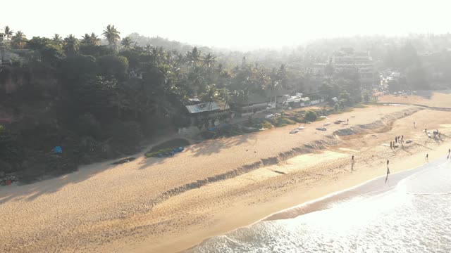 在印度喀拉拉邦瓦尔卡拉，沐浴在阿拉伯海温暖海水中的热带金色沙滩视频素材