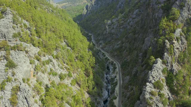 陡峭的悬崖和峡谷，有松林。弯弯曲曲的山路，土耳其小河。鸟瞰图4 k。视频素材