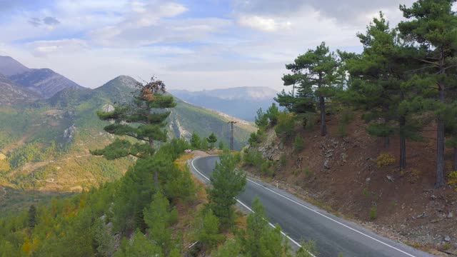 松林在蜿蜒的山路上走向美丽的山峦。Manavgat,土耳其安塔利亚。鸟瞰图4 k。视频素材