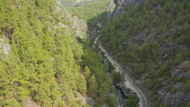 陡峭的悬崖和峡谷，有松林。弯弯曲曲的山路，土耳其小河。鸟瞰图4 k。视频素材