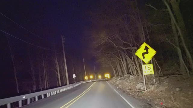 在乡村的高速公路上行驶，在夜间穿过山区的森林。视频素材