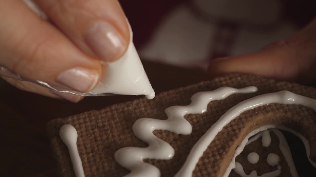 女人女孩装饰圣诞节姜饼，做一个房子皇家糖衣视频素材