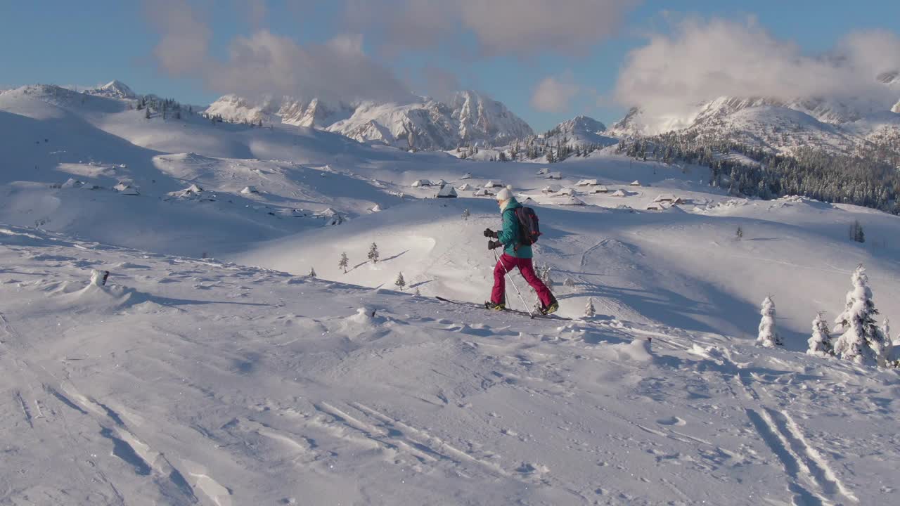 无人机:在Velika Planina女子滑雪旅游时，一个雪谷的壮观镜头。视频下载