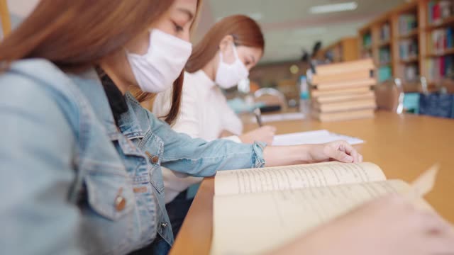 女大学生在大学图书馆看书视频素材