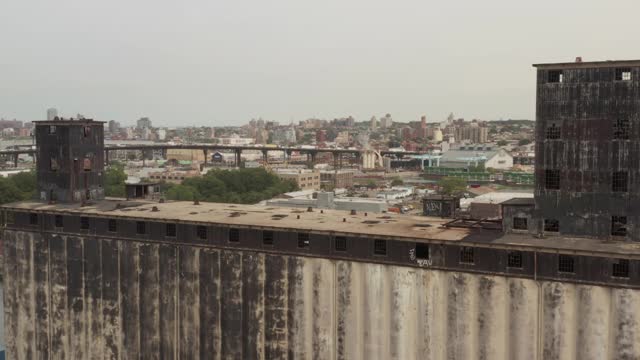 缓慢的空中摄影车穿过谷物码头，穿过纽约市港附近的大桥，驶向繁忙的城市交通视频素材