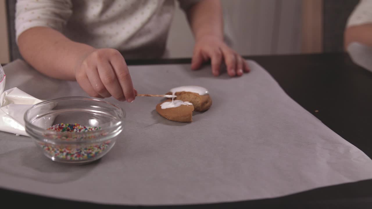 一个女孩用牙签在姜饼上洒糖霜视频素材