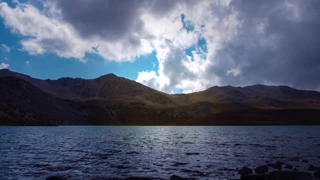 山冰碛湖在秋季与蓝色多云的天空，时间流逝。美丽的风景。宁静的背景,阳光。田园诗般的风景。美丽的高山景观。山徒步旅行。视频素材