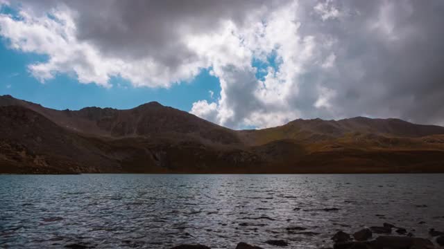 山冰碛湖在秋季与蓝色多云的天空，时间流逝。美丽的风景。宁静的背景,阳光。田园诗般的风景。美丽的高山景观。山徒步旅行。视频下载