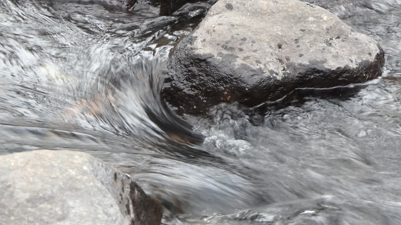 湍急的水流在两块岩石之间流动的特写视频素材