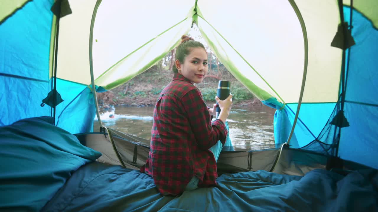 一个年轻的女旅行者正在帐篷露营中享受大自然。视频素材