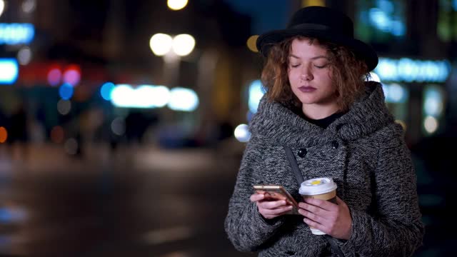 晚上在市中心打电话的时髦女人视频素材