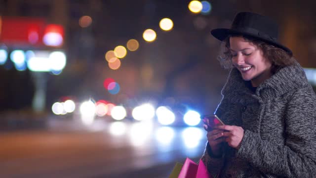 晚上在市中心打电话的时髦女人视频素材