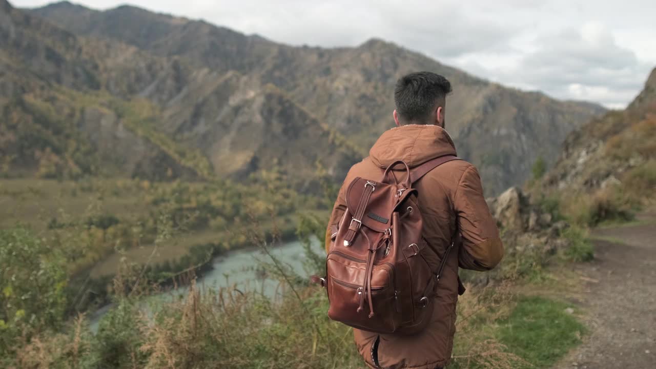 胡子有吸引力的年轻徒步旅行者旅行者与背包旅行在山上视频素材