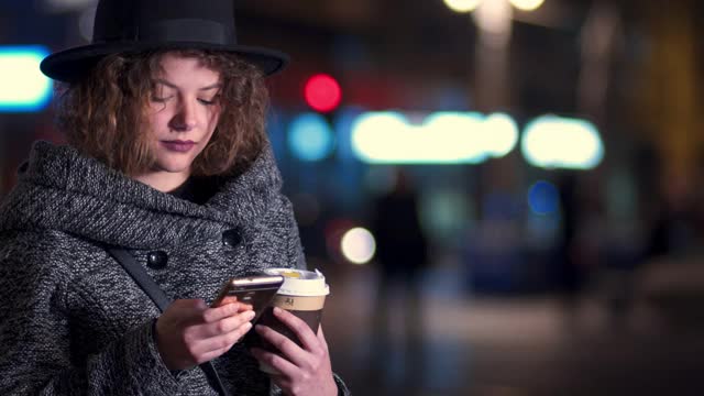 晚上在市中心打电话的时髦女人视频素材