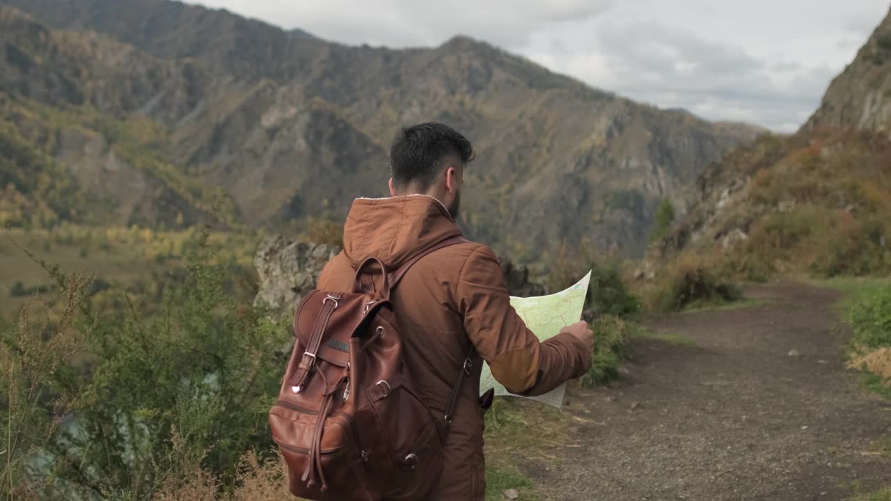 胡子有吸引力的年轻徒步旅行者旅行者与背包看地图视频素材