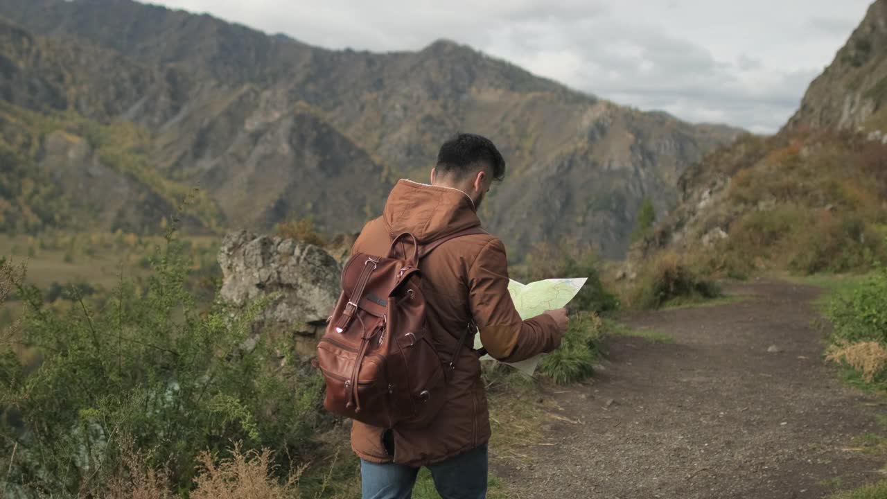 胡子有吸引力的年轻徒步旅行者旅行者与背包看地图视频素材