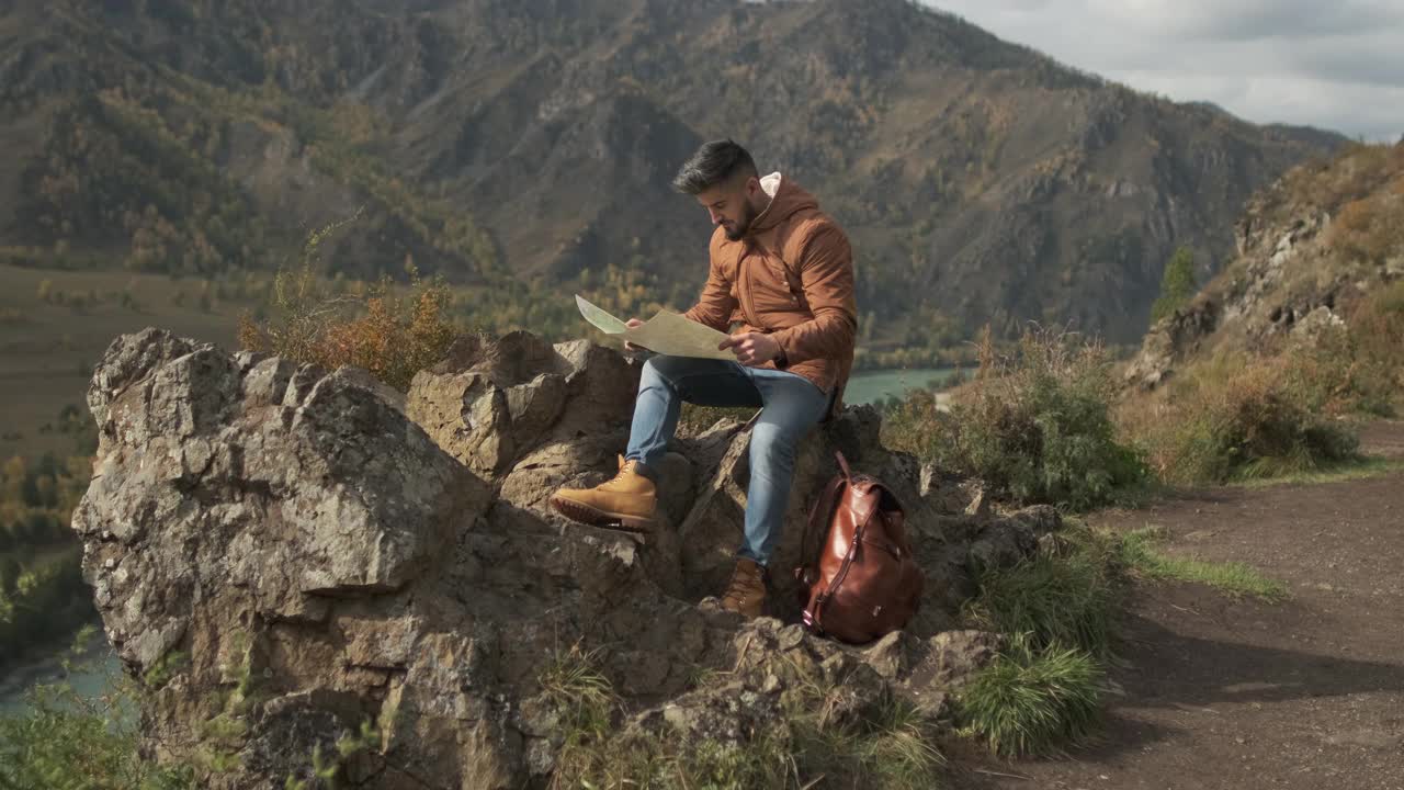 胡子有吸引力的年轻徒步旅行者旅行者与背包看地图视频素材