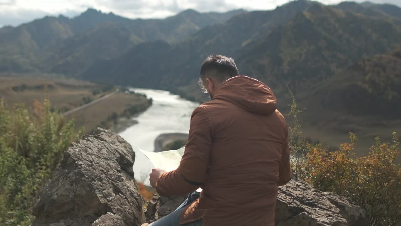 胡子有吸引力的年轻徒步旅行者旅行者与背包看地图视频素材