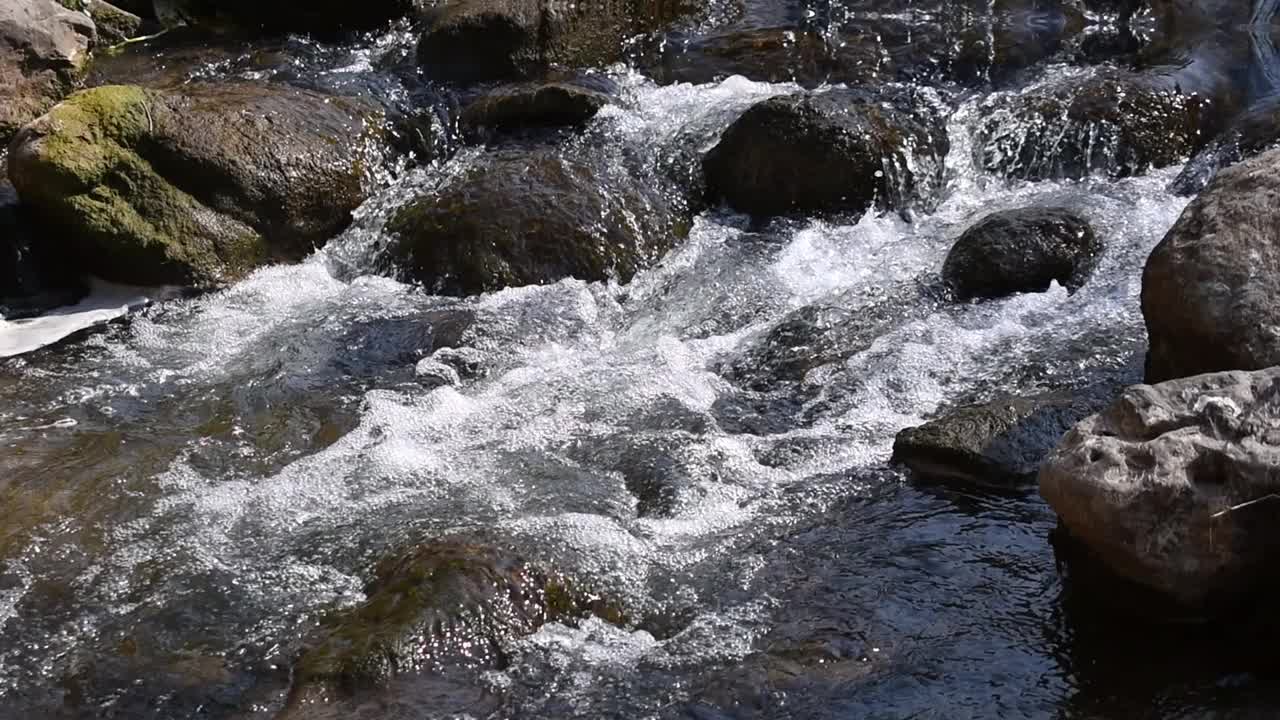 波浪冲击着岩石，在河里产生泡沫视频素材