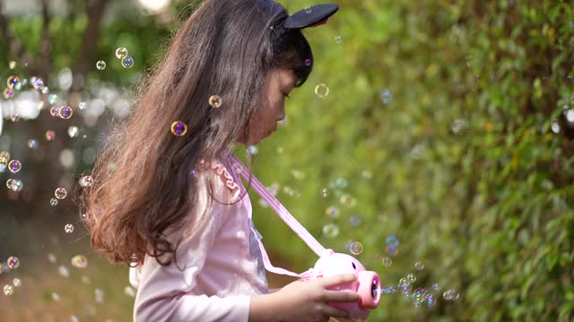 小女孩在家里的花园里玩泡泡视频素材