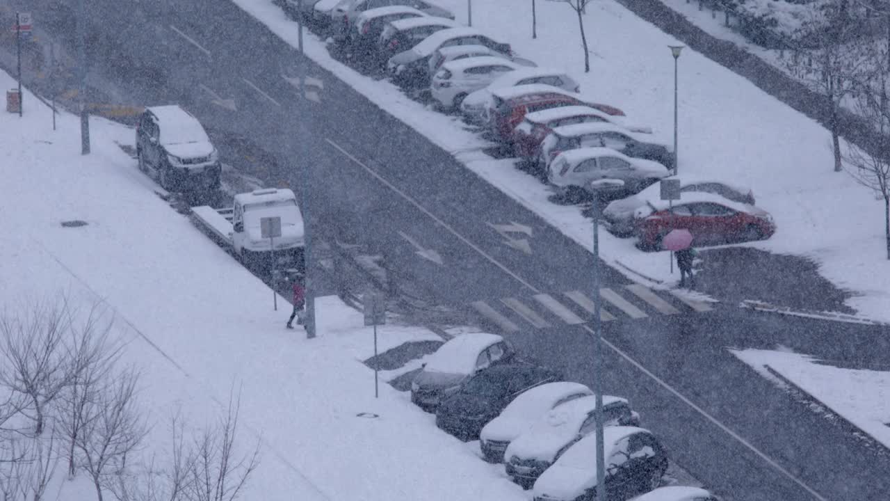 在大雪纷飞的冬日，人们走过马路视频素材