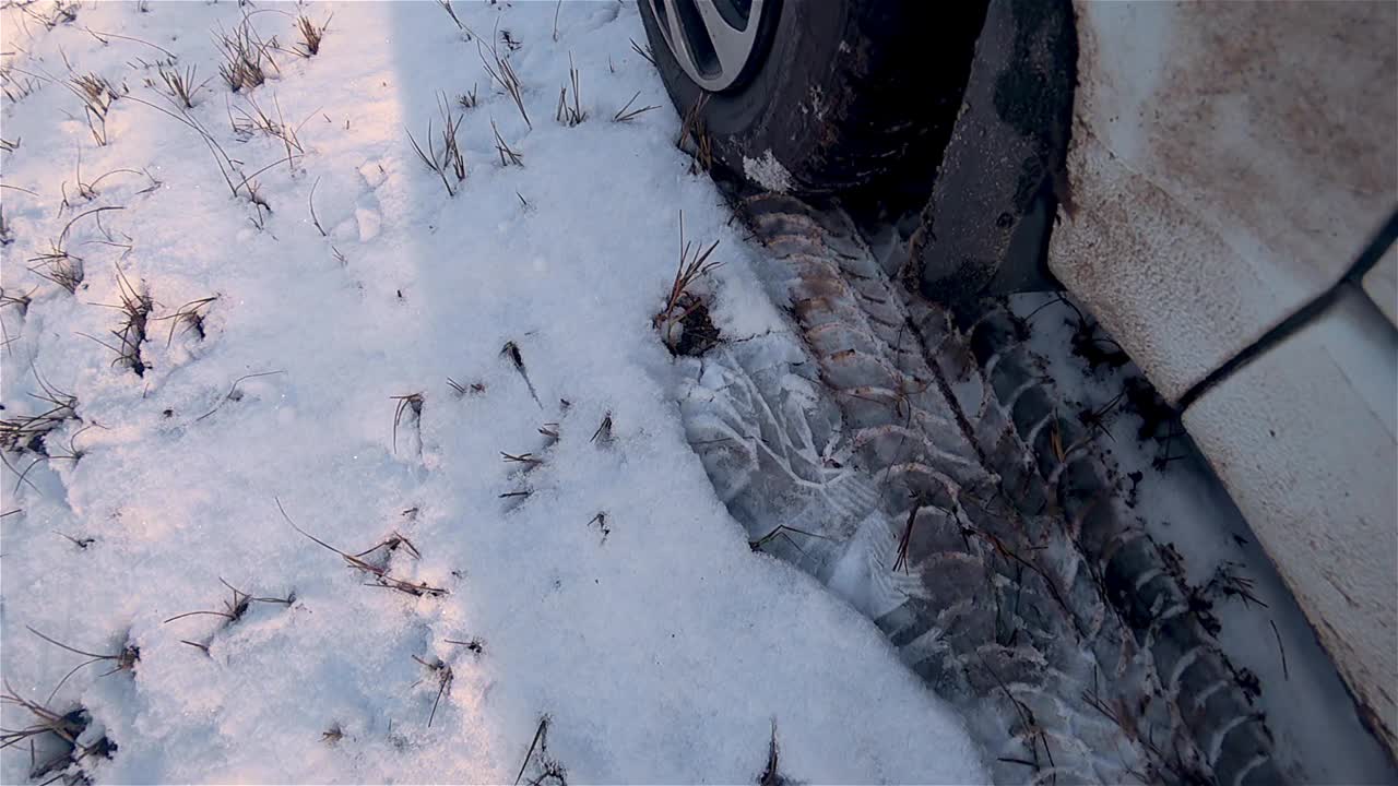 近距离的车轮强大的汽车在雪开始运动与滑和飞溅直进入相机视频素材