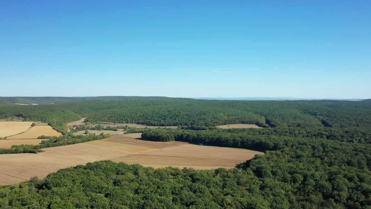 在法国勃艮第Nièvre的Cuncy les Varzy村，夏日和阳光明媚的一天，收获后的麦田和Mhers hammeau的绿色森林。视频素材