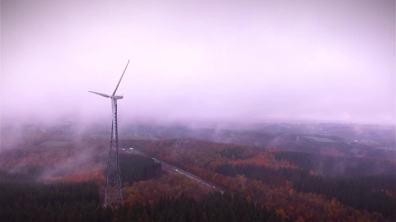 风力涡轮机在雾与高速公路的背景-鸟瞰图视频下载