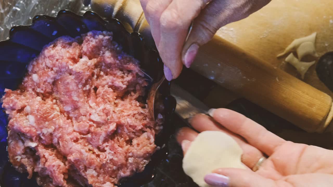 自制的肉饺子。雕刻饺子。厨房里煮着肉馅饺子。准备自制的饺子。烹饪的过程视频素材