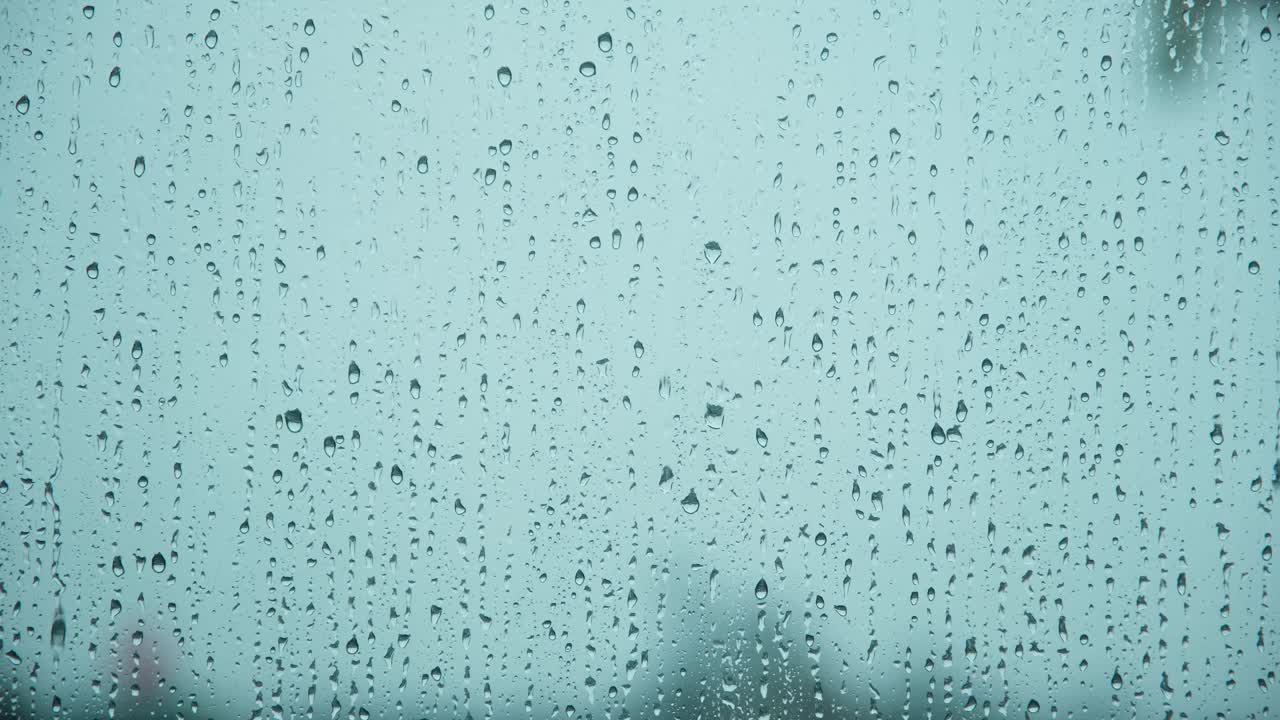 雨点落在窗户玻璃上，雨点落在窗户玻璃上，近距离的水滴下落。视频素材