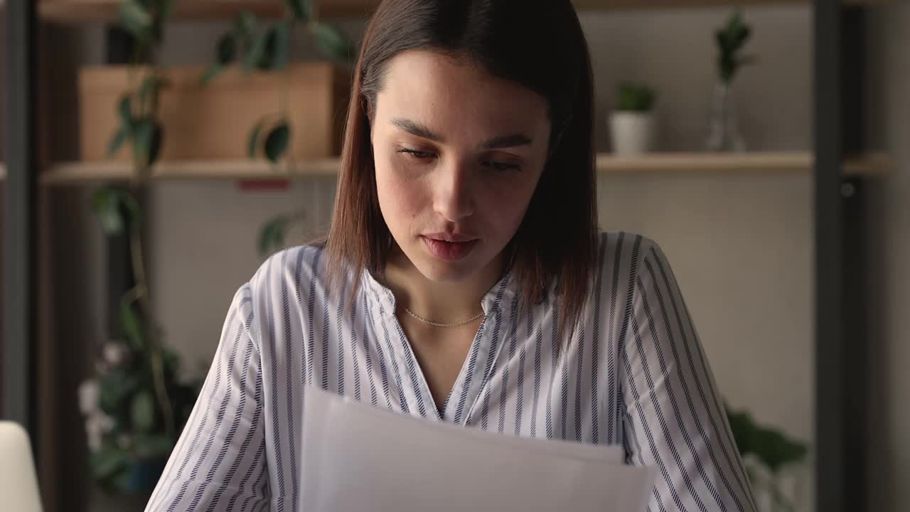 心情愉悦的千禧女商人在办公室里阅读纸质信件。视频素材