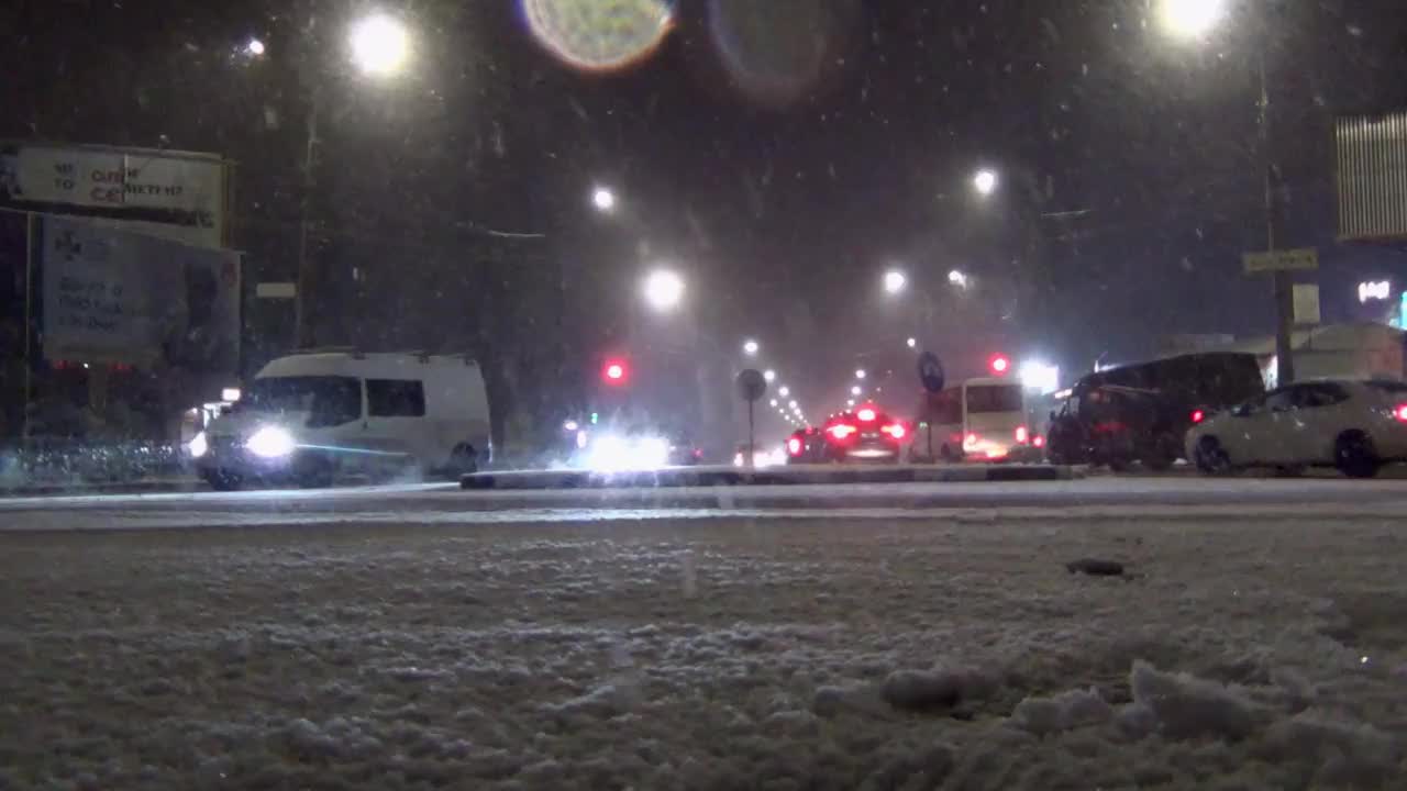 在大雪期间，汽车在城市街道上行驶视频素材