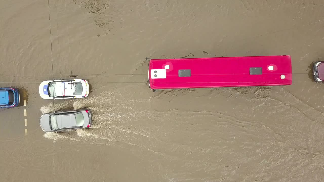 交通车辆在被雨水淹没的道路上行驶的鸟瞰图。视频素材