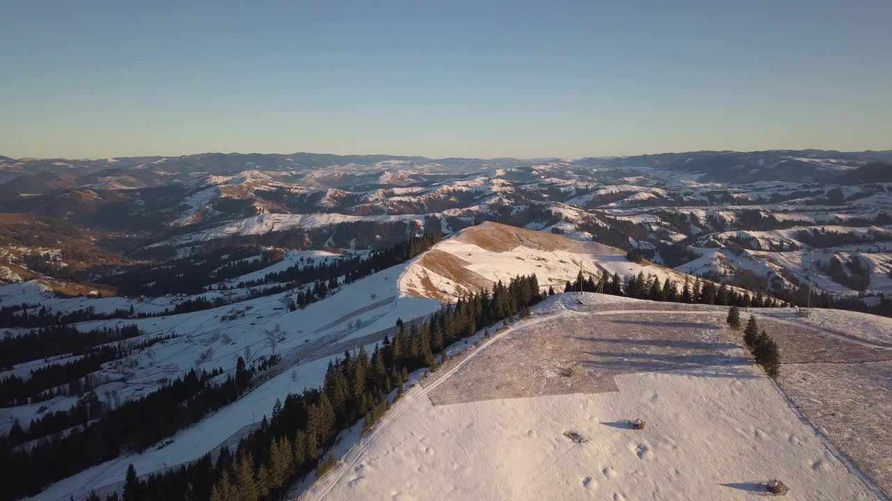 鸟瞰图上的小村庄，在冬天被雪覆盖的山丘上散落着房屋，裸露的喀尔巴阡山脉在乌克兰。视频素材