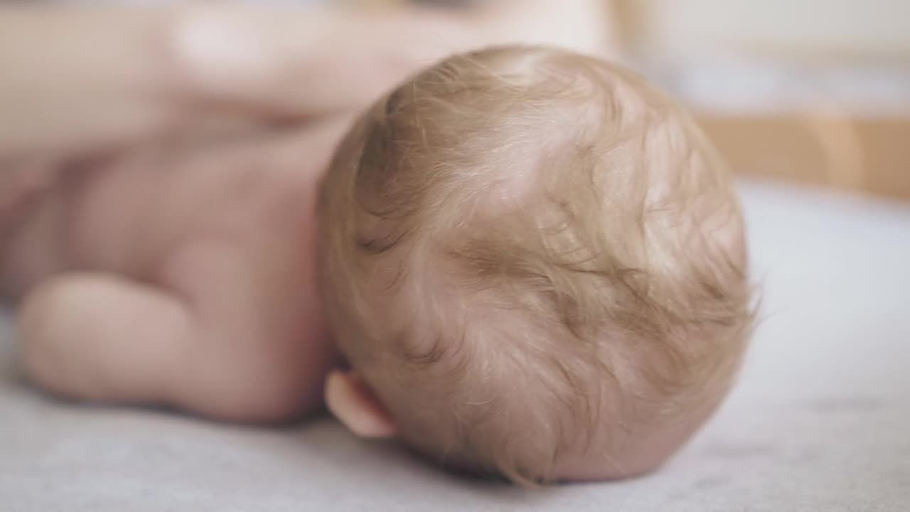 新生男婴躺着，儿科医生在按摩视频素材