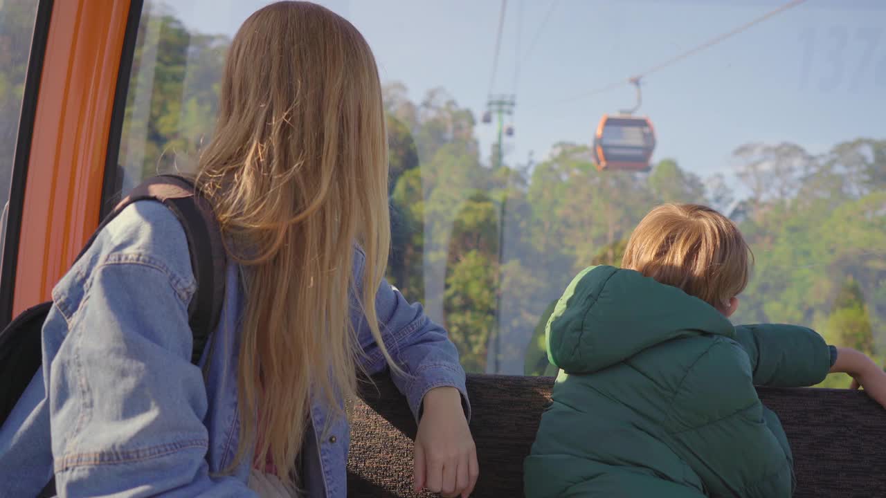 一位妇女和她的儿子乘坐缆车上山前往岘港市的巴那山度假村视频素材