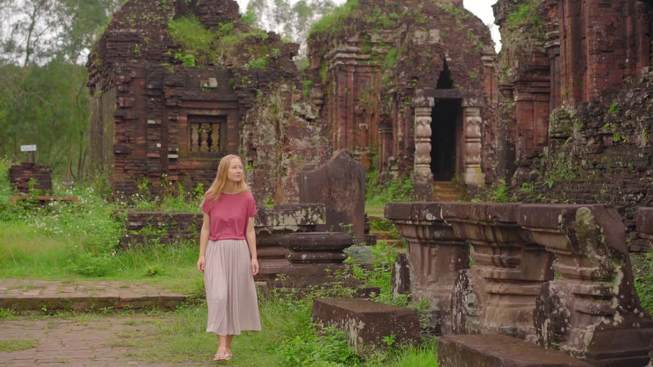 一名年轻的女游客正走过我的儿子庇护所的废墟，这是越南古代占族文明的遗迹。岘港市的旅游胜地。去越南旅游的概念视频素材