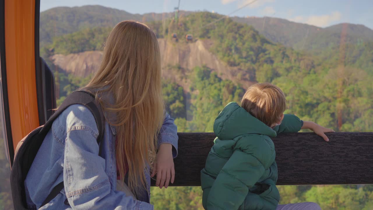 一位妇女和她的儿子乘坐缆车上山前往岘港市的巴那山度假村视频素材