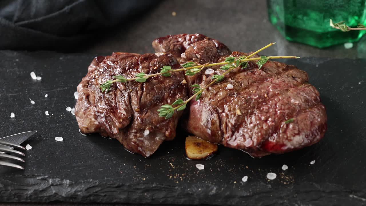 近距离的烤牛肉肉与香料在黑色的石头盘子，俯视图放大视频素材